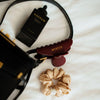 Azerum Premium Kopfhautserum Scalp Serum Made in Germany als Lifestyle-Flatlay mit Handtasche, Azerum Haarklammer und Seiden-Scrunchie